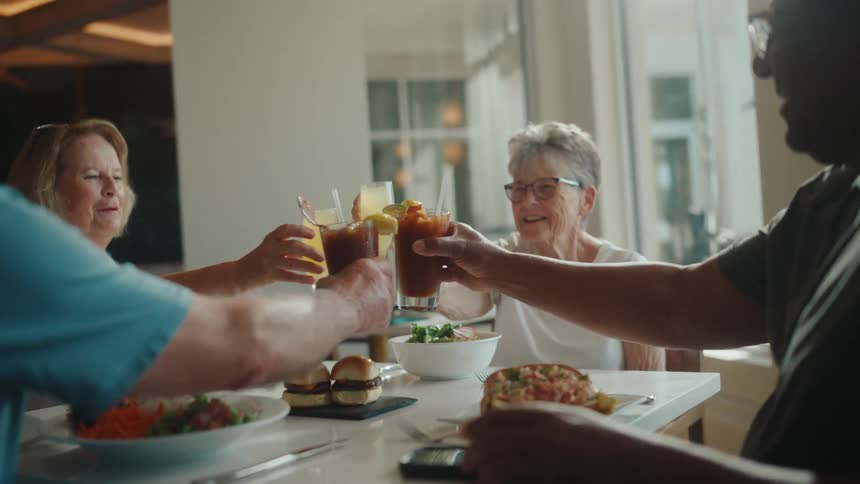 A group of people toast their glasses in a restaurant