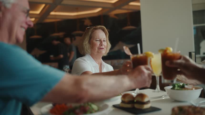 Four people sitting at a table toasting