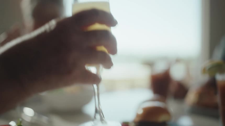 A person takes their drink from the table