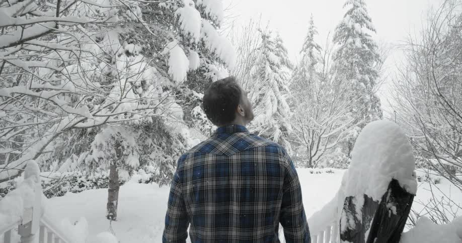 Man standing outside looking up at the snowy wonderland