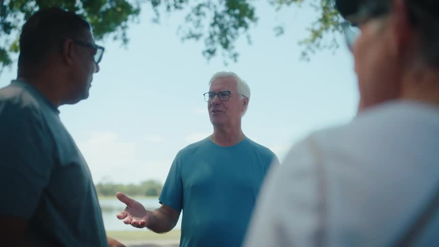 A group of friends talk by the lake
