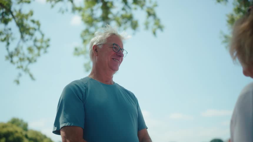 An older man and woman have a conversation outdoors