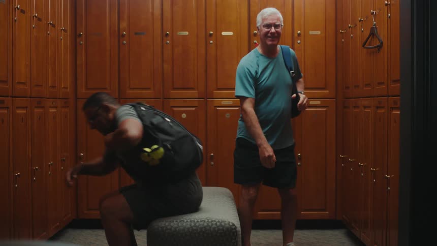 Two men leaving a changing room with backpacks on their backs