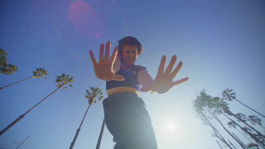 Woman dancing in an openair environment with palm trees around