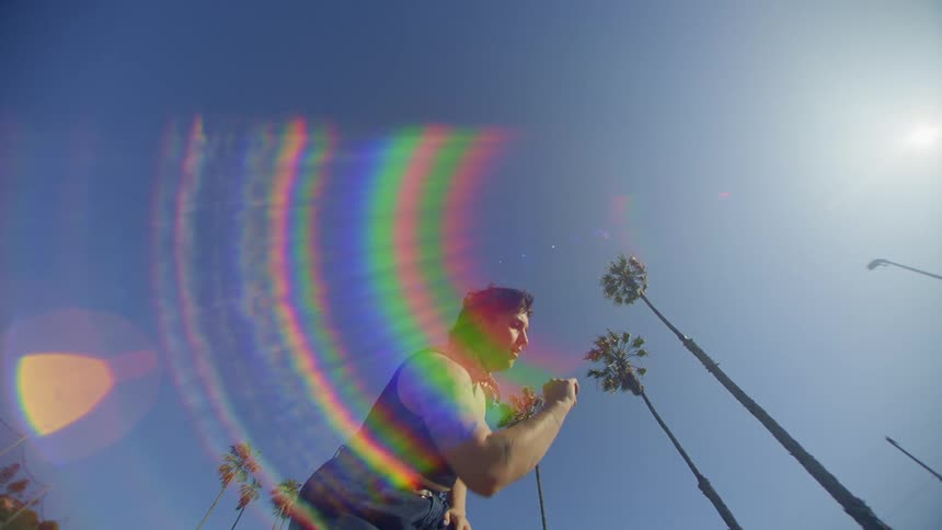 A white woman dances under a blazing sun