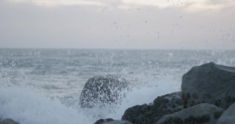 A wave crashes against the rocks