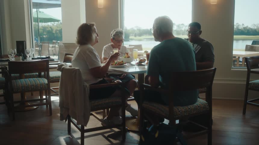 Four older people eat together in a restaurant