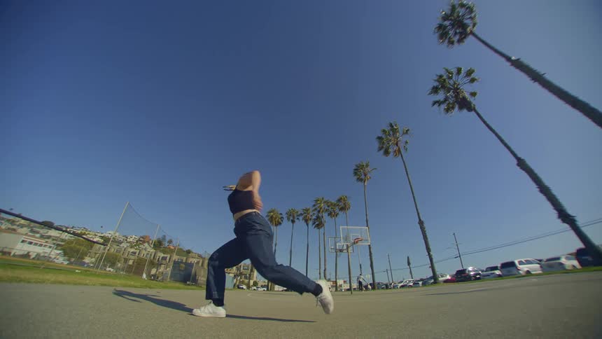 Outdoor setting with a woman in jeans dancing
