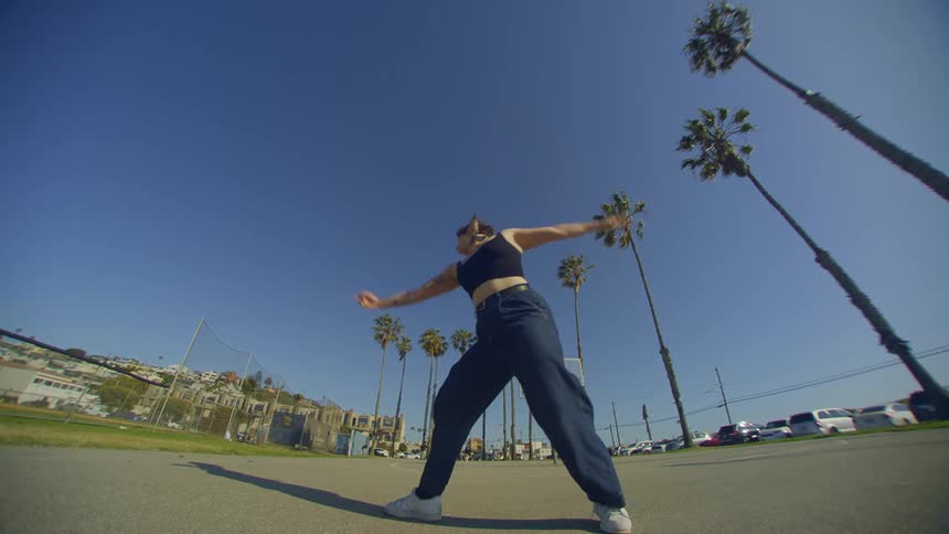 Woman in jeans in a park during the day dancing