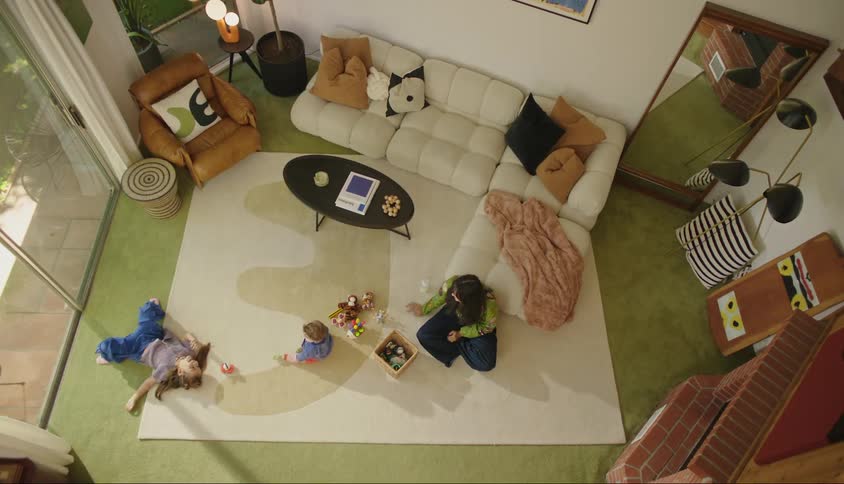 A mother watches her daughter roll on the ground