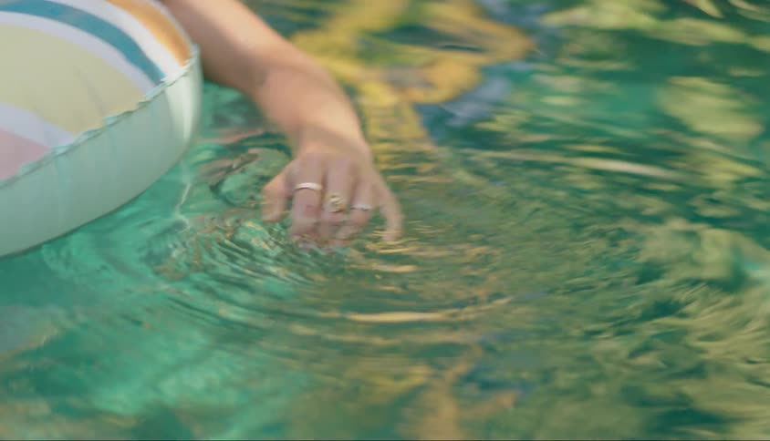 A woman is floating in the pool