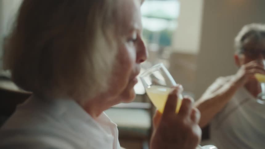 Friends eating together at a restaurant click their glasses together