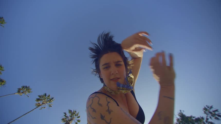 Top view of a woman placing her hands on her face and dancing