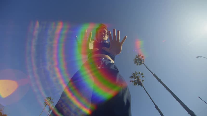 The sun glares on the woman dancing outside