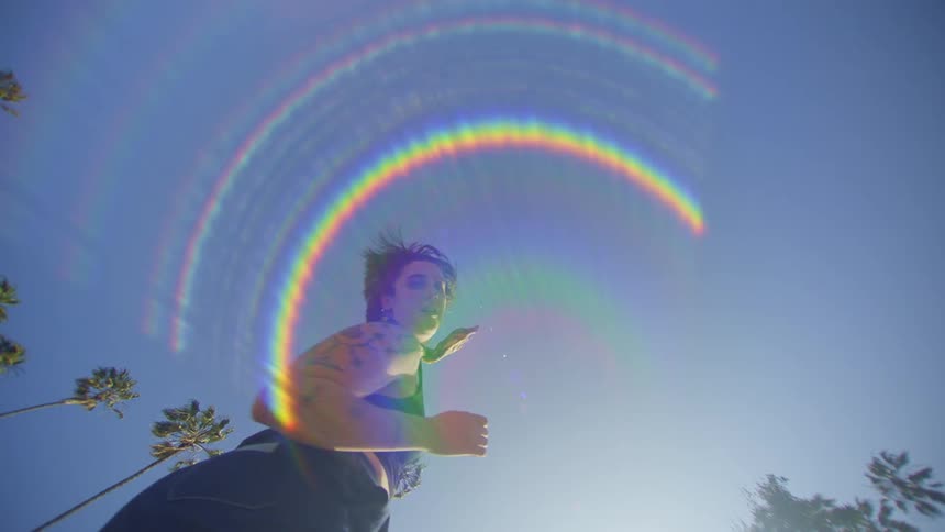 A woman spins around dancing on a sunny day