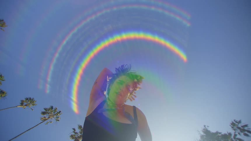 Portrait of a young woman dancing in an openair environment with a cloudless blue sky
