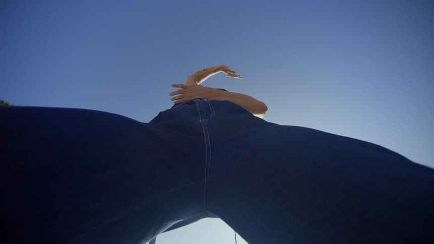 Upward view of a womans legs dancing in an openair environment