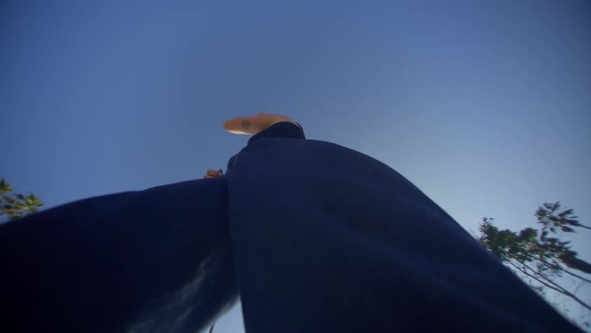 A woman is dancing under a clear sky