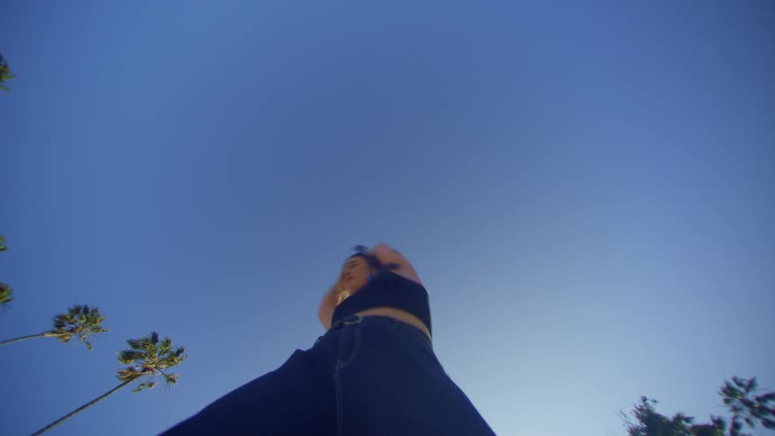 Upward view of a woman in jeans dancing