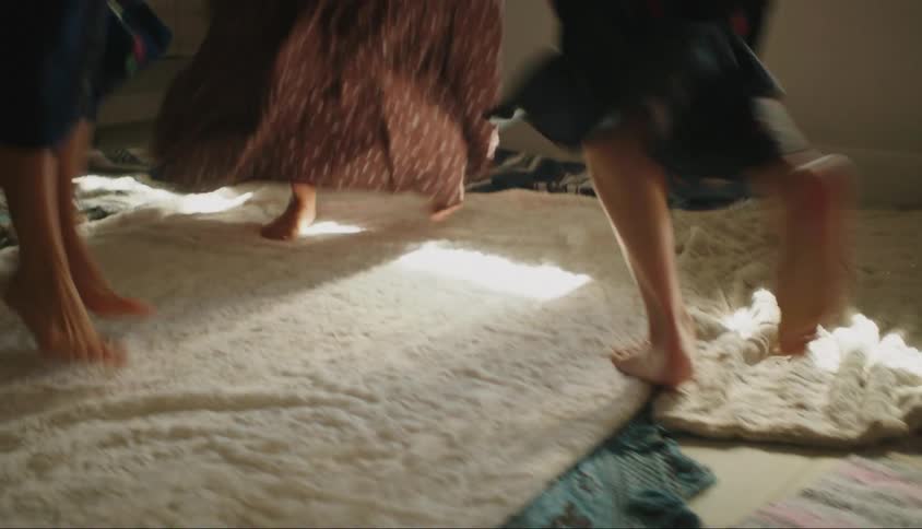 Three women dance in a circle in the room