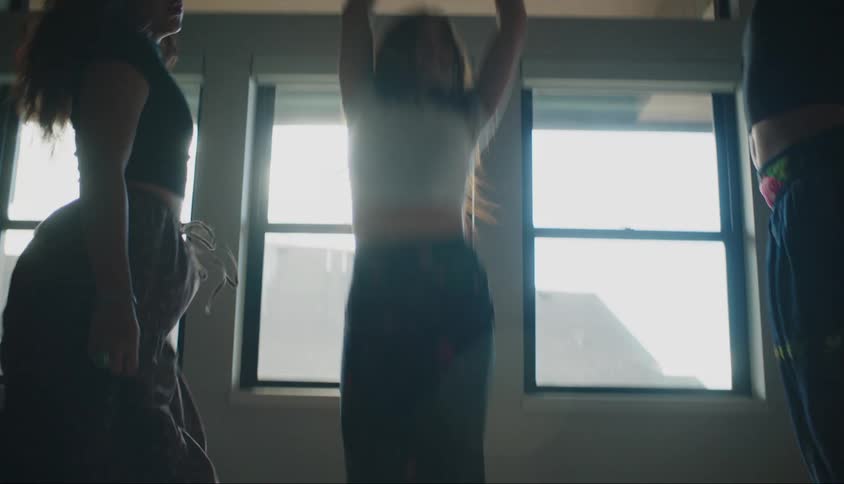 Three women dance and jump around