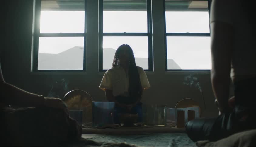 Three people sitting in a room in a ritual with smoke essences
