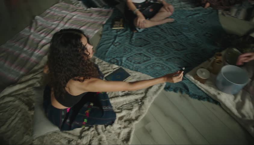 Three people sitting in a room passing essence in a ritual