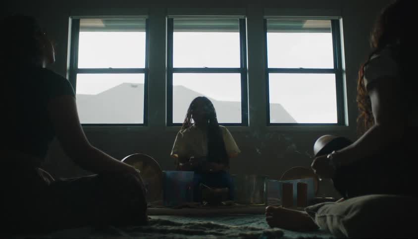Woman sitting with two others in a room reading letters