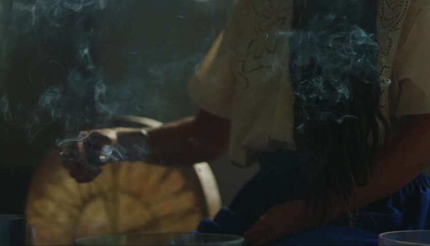 A woman is waving around incense