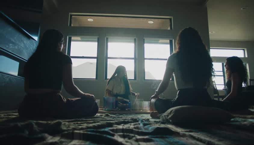 Four women are sitting in a circle with incense