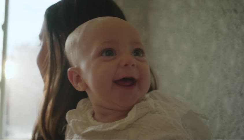 Mother holding her smiling baby on her lap