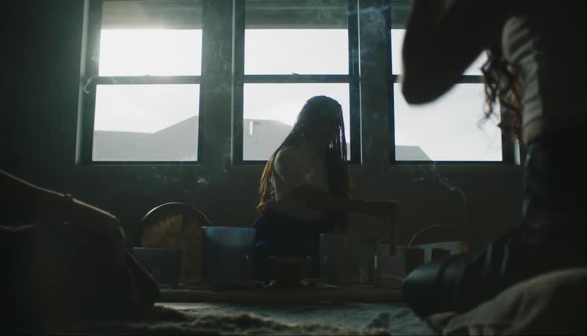 Silhouette of three women sitting in a room applying essence with smoke around their bodies