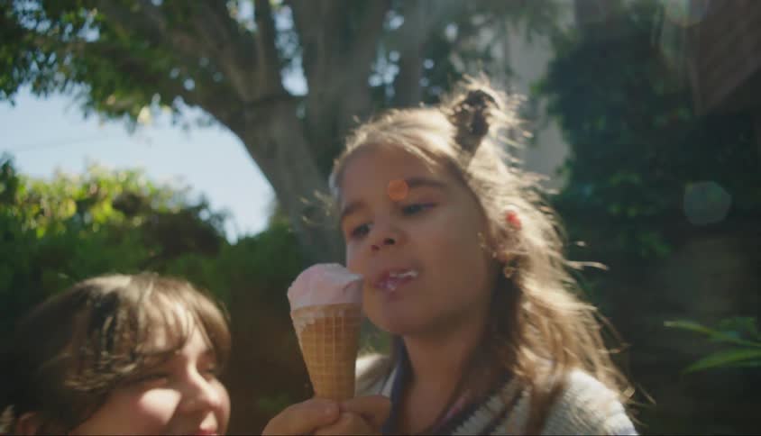 Mother watching her daughter sucking on ice cream