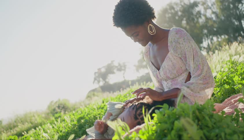 Child lying on his mothers lap in a garden