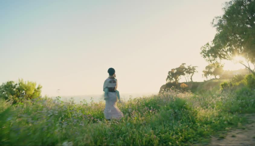 A mother spins her daughter around by the cliff