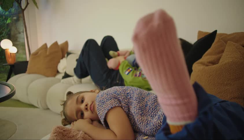 A mother and her children lounging on a couch in the living room