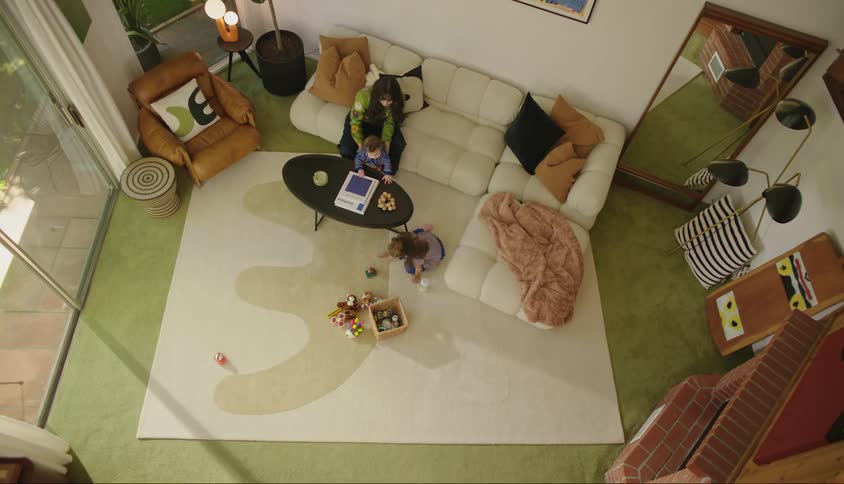 A mother watches her children play in the living room