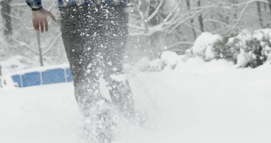 A man is running in heavy snow