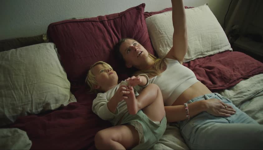 A mother talks to her son in bed