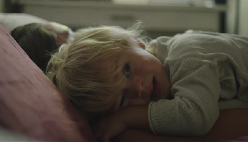 A little blond boy is on someones lap and is being patted on his back