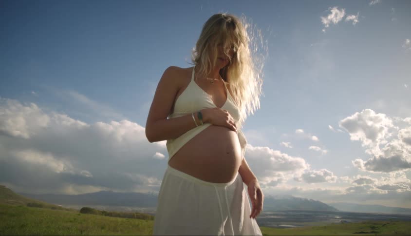 A pregnant woman moving around in nature