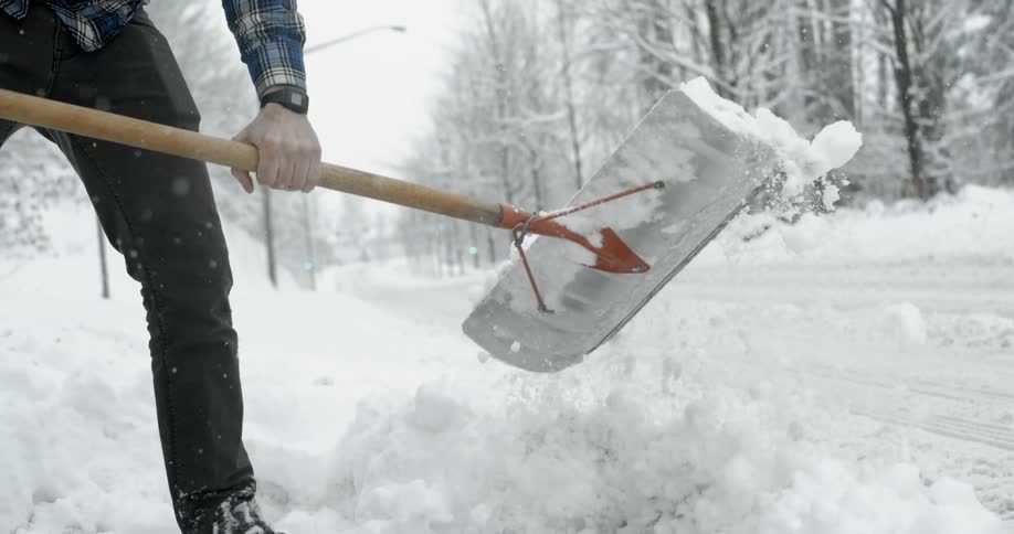 A man shovels snow on a snowy day