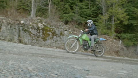 Person riding his dirt bike up a country road