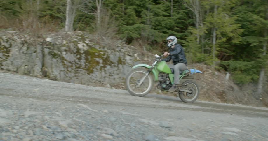 Person riding his dirt bike up a country road