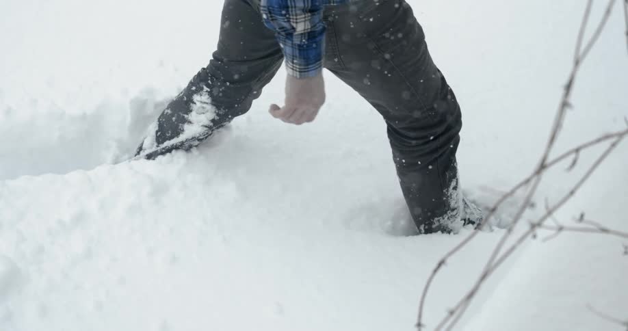 Person trudging through deep snow as seen from the waist down