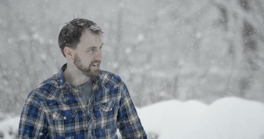 A man stands in the snow on a winter day