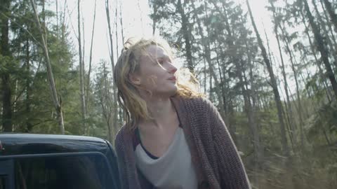 A woman rides in the back of a truck