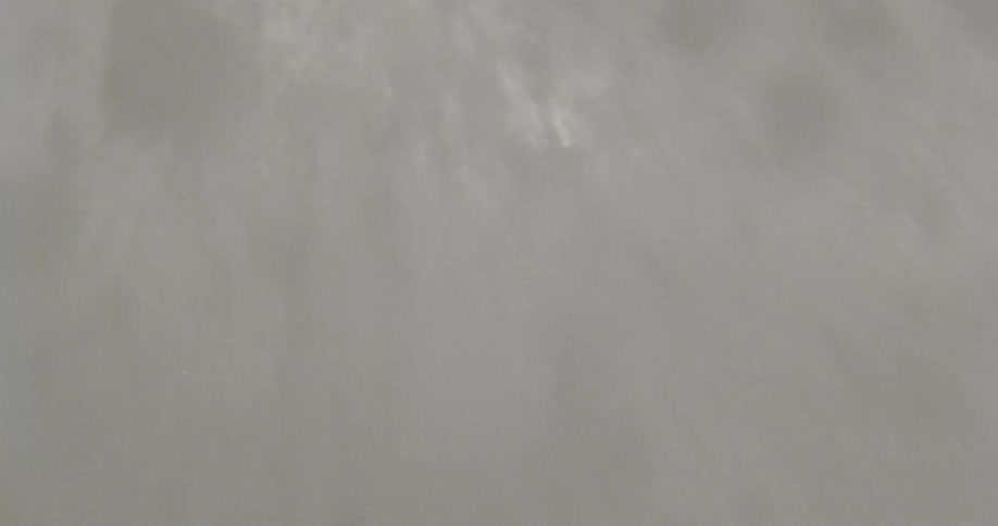 Person descending a mountain with snowboard maneuvers during the day
