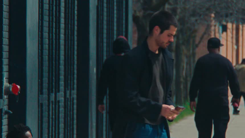 Bearded man counting money notes and handing them to a beggar who is sitting on the sidewalk of a street
