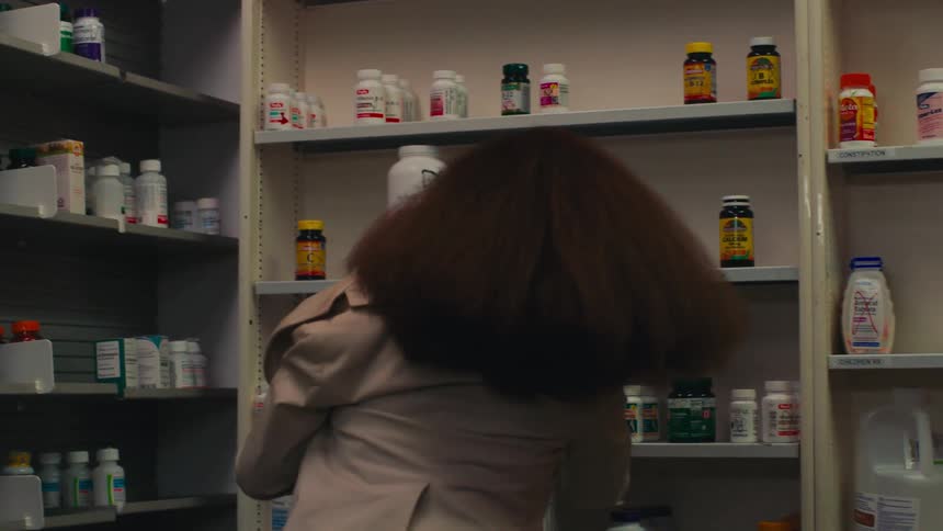 Woman picking up a medicine in a pharmacy